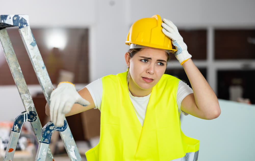 Sad woman builder standing in construction site
