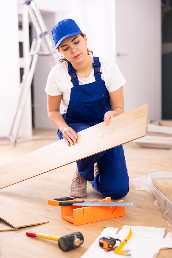 Female carpenter taking out laminate planks from package