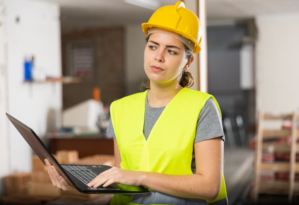 Woman with laptop on indoor construction site