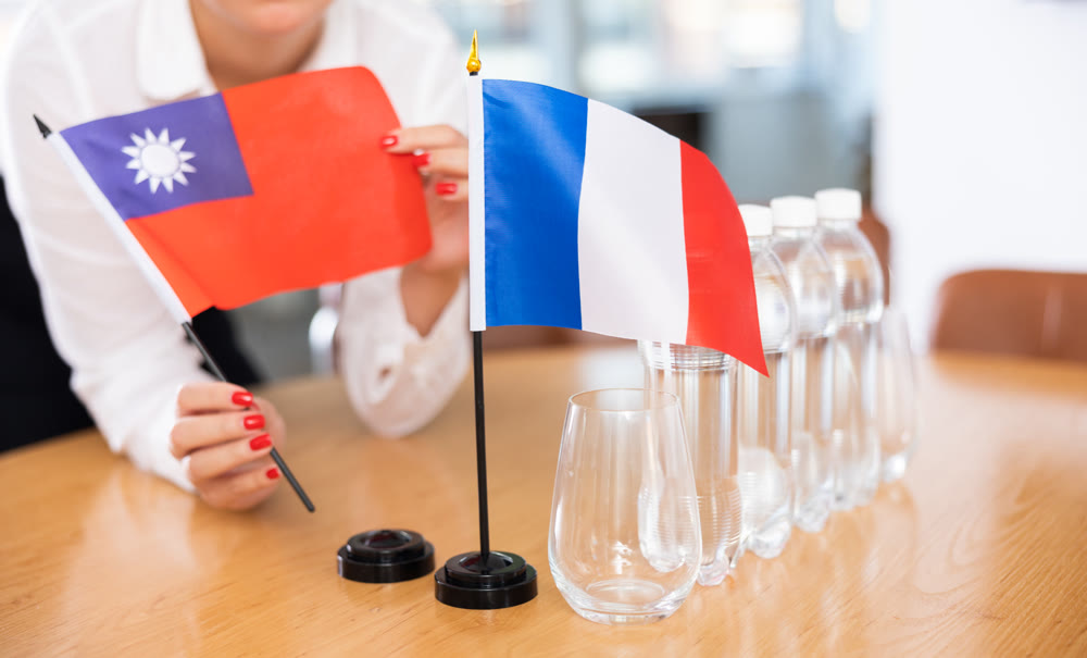 Flags of Taiwan and France stand on negotiating table in office