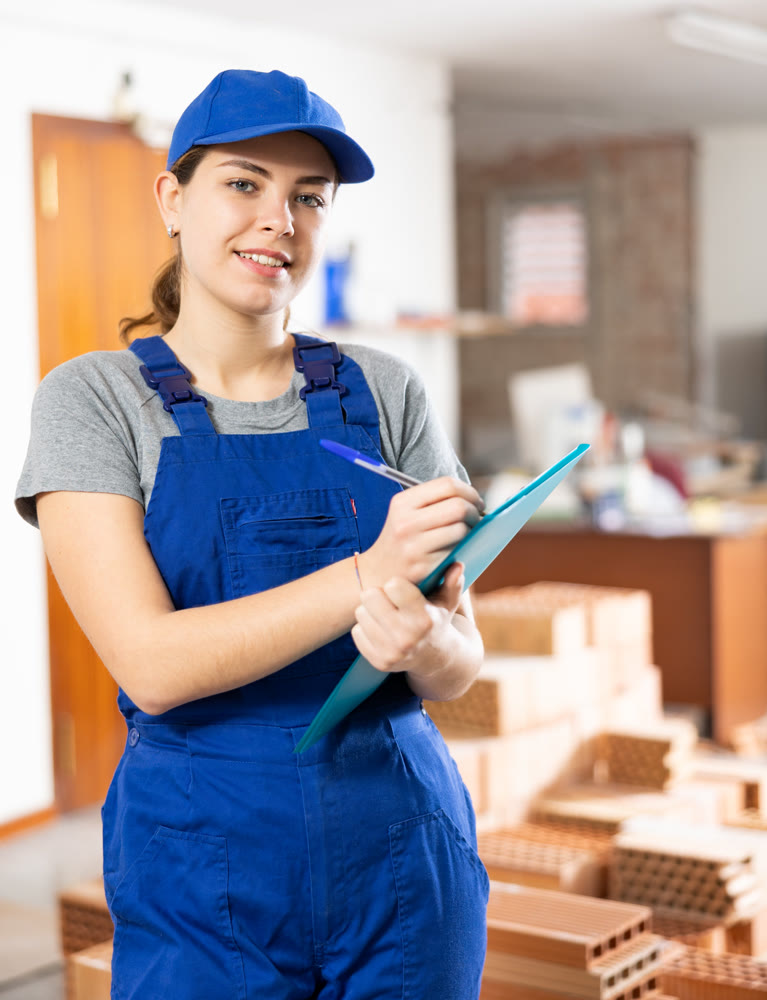 Young woman construction worker standing inside apartment