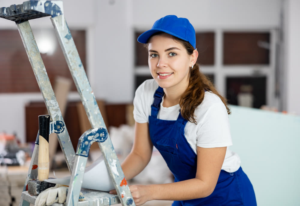 Young woman builder with documents in construction site