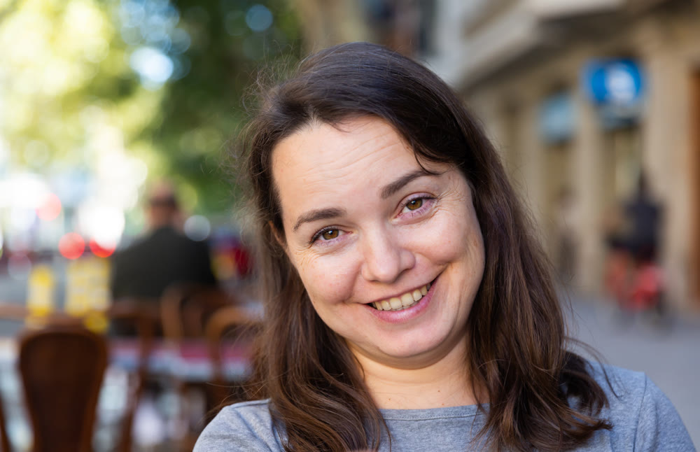 Closeup portrait of cheerful brunette on city street