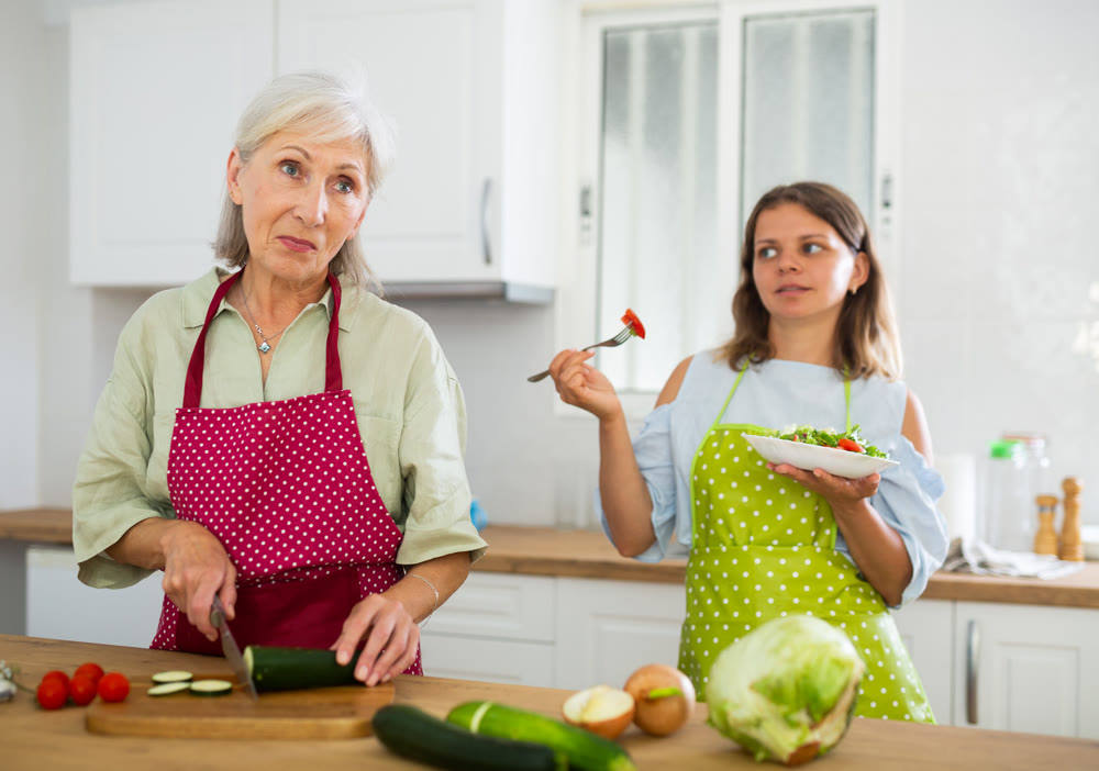 Elderly woman and her daughter preparing salad
