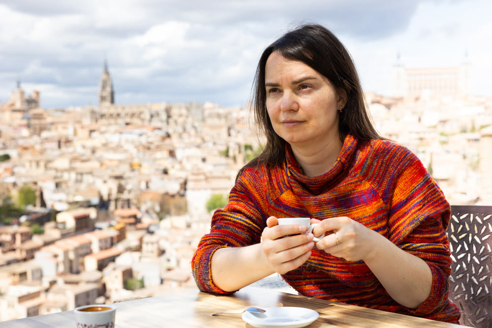 Portrait of a woman traveler sitting at a table and holding a cup of coffee