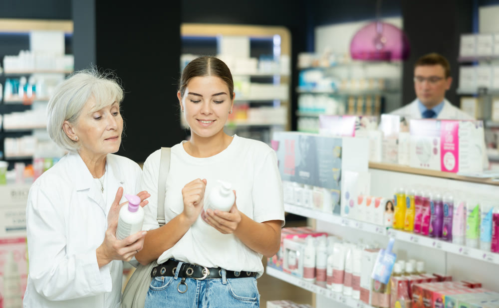 Young girl asking old female pharmacist for advice concerning intimate hygiene product