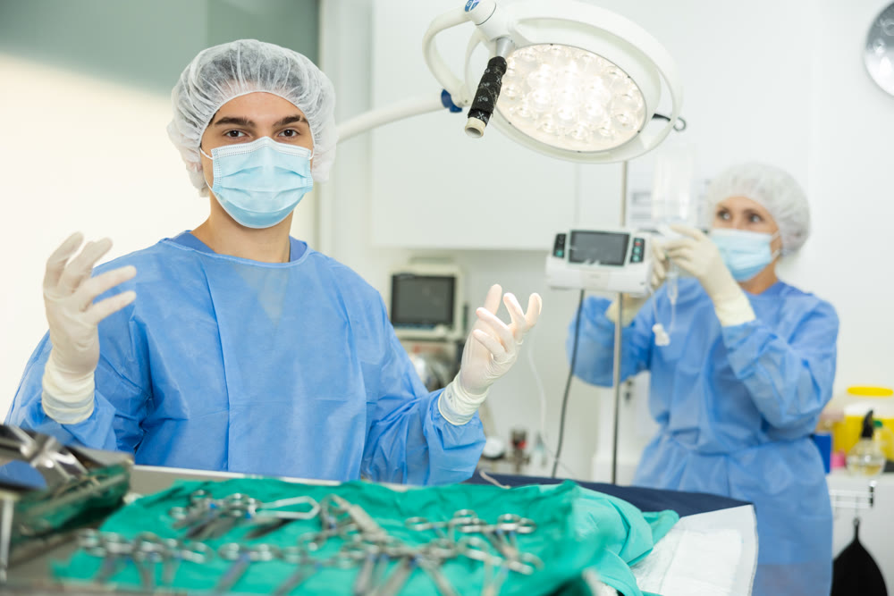 Young veterinarian in surgical attire standing in veterinary operating room