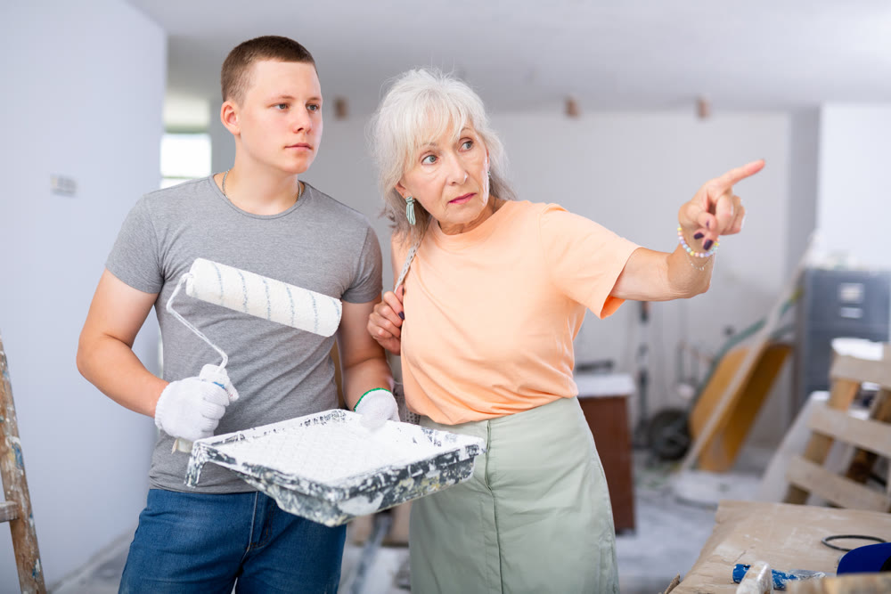Woman talking with painter on construction site