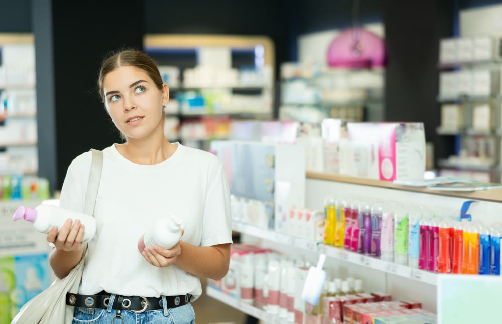 Girl customer chooses gel for intimate hygiene in chemist shop
