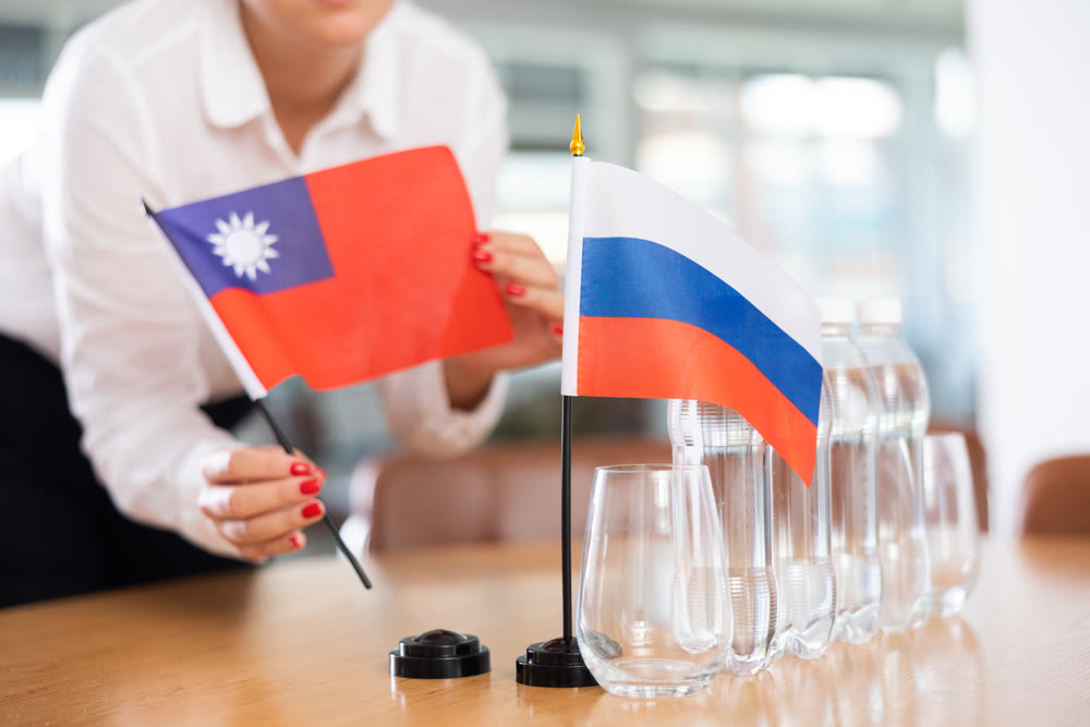 Flags of Taiwan and Russia stand on negotiating table in office