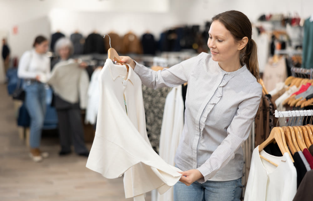 Satisfied woman trying on a new jacket in clothing boutique