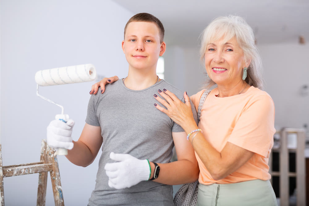 Teenager posing with grandmother in renovated house