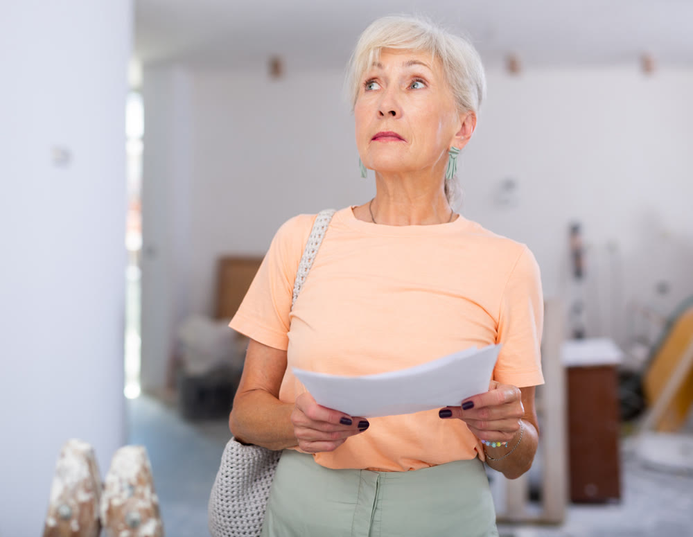 Mature woman checking completed construction work on drawing