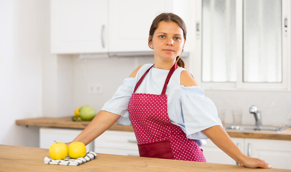 Young woman in apron posing in kitchen
