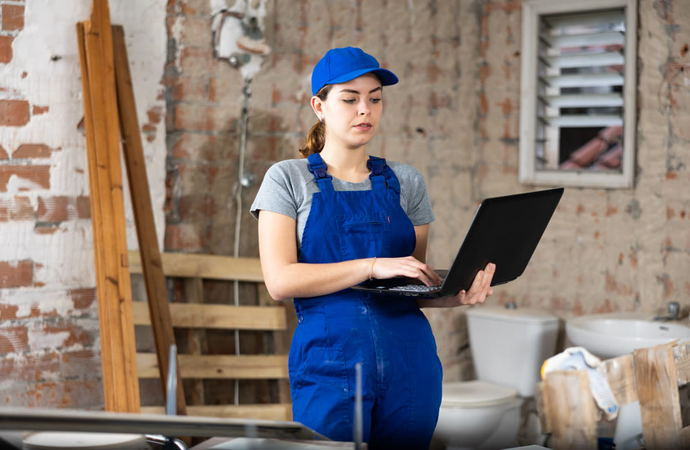 Female engineer using laptop in apartment