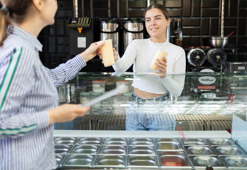 Young woman works as bartender and sells bubble tea