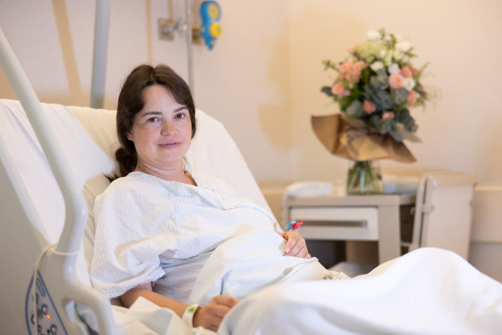 Female patient recovering after surgery in comfortable hospital room