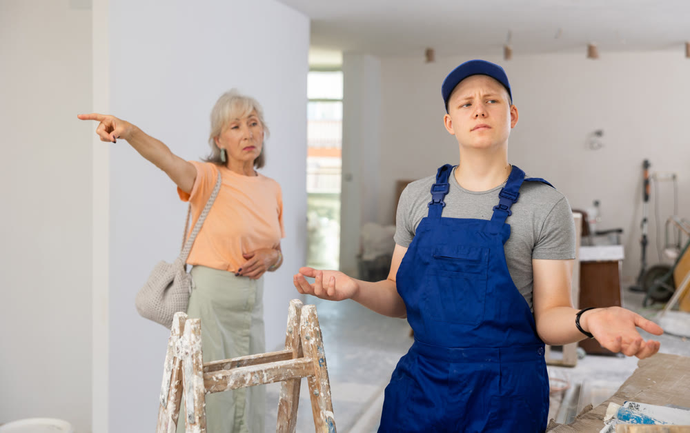 Disgruntled mature woman points out something to a fifteen-year-old worker