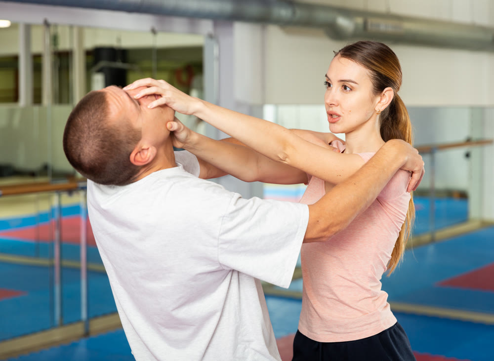 Girl using painful technique for eyes to opponent in self-defense training