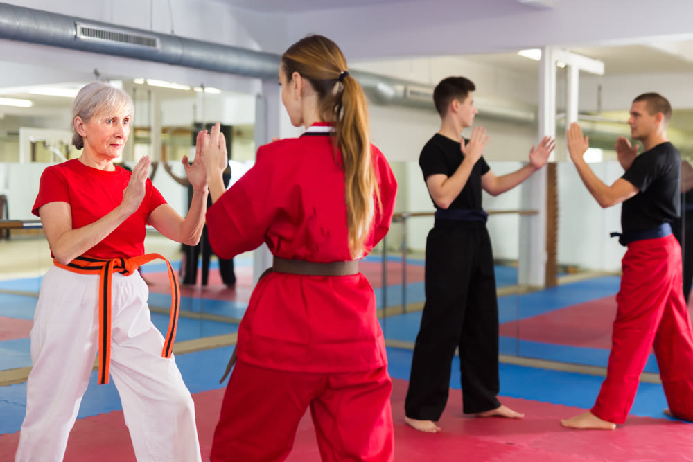Senior and younger women sparring during group karate training