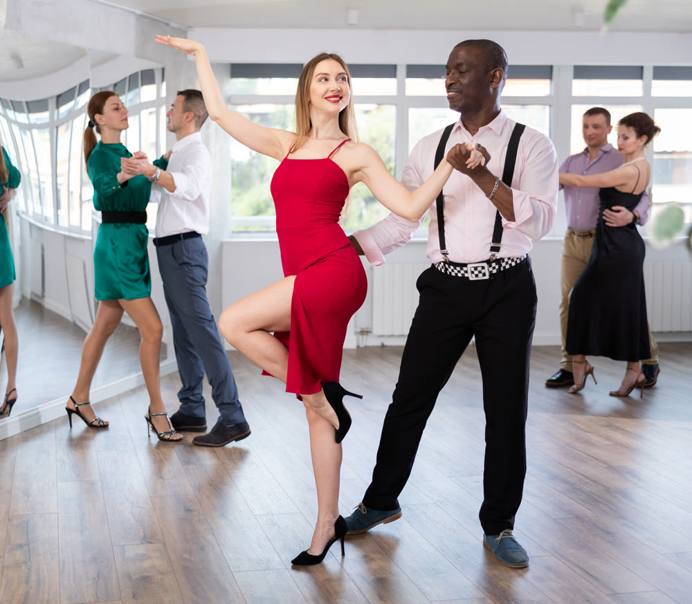 Man and young woman practicing waltz in dancing studio
