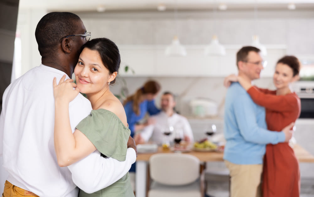 Happy middle-aged men and women doing slow dance in pairs
