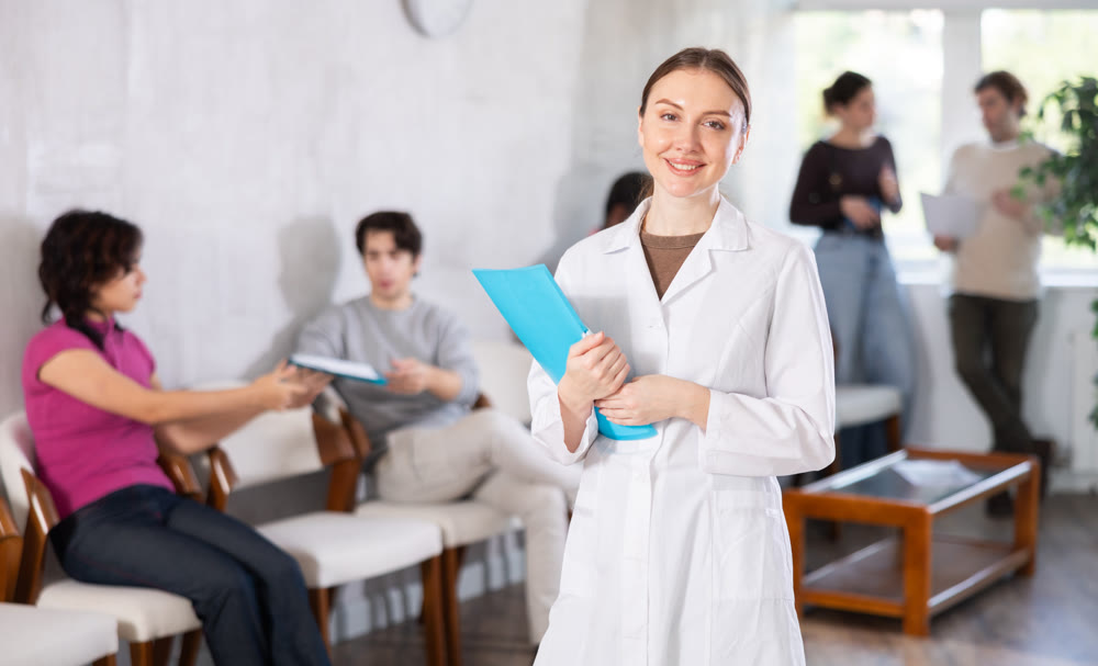Young female nurse inviting patients in clinic