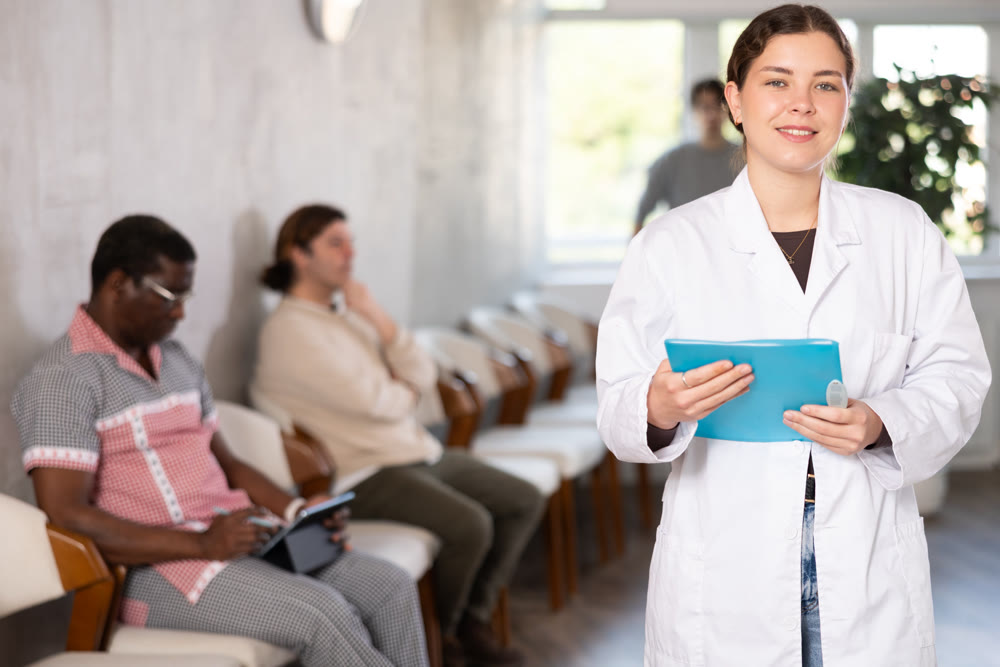 Female doctor in medical uniform posing in clinic reception