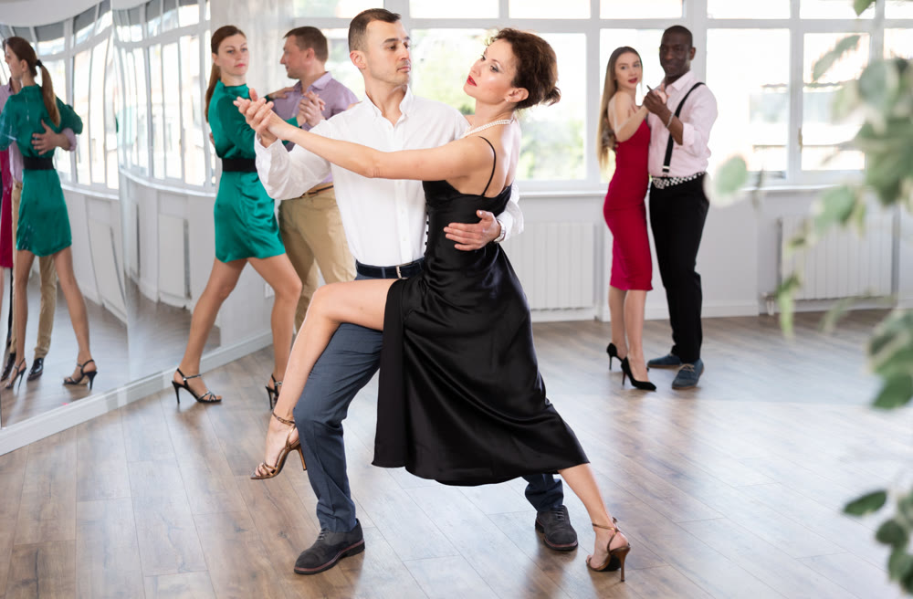Woman dances incendiary tango with man partner during choreography lesson