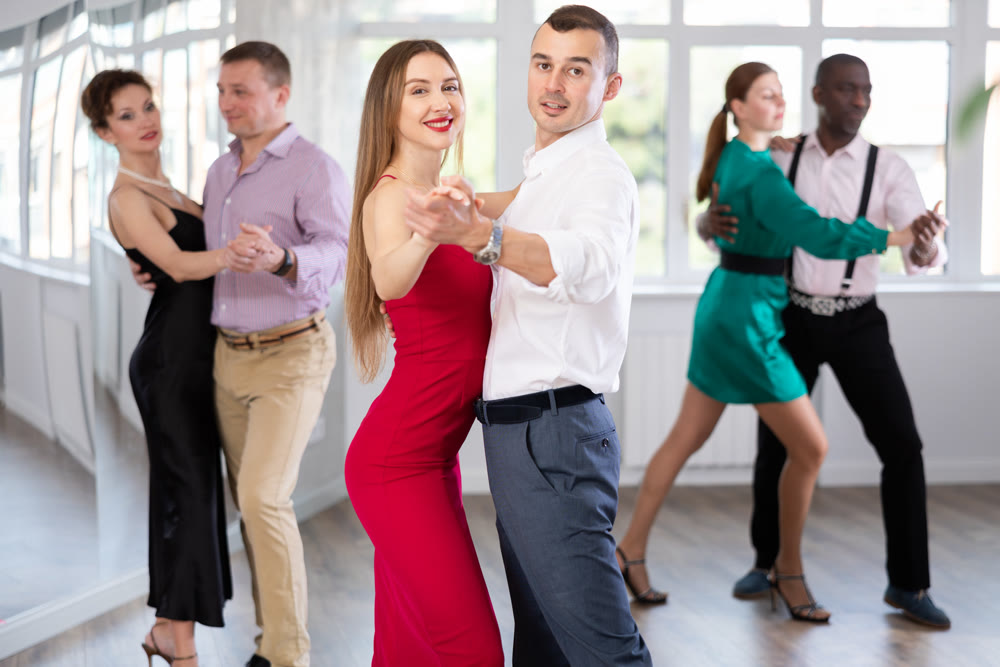 Young man and woman practicing waltz in dancing studio