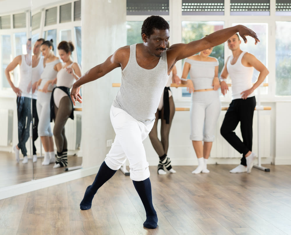 Adult man teacher showing ballet movements