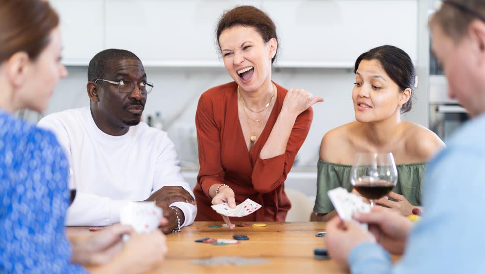 Multiethnic women and men friends playing poker