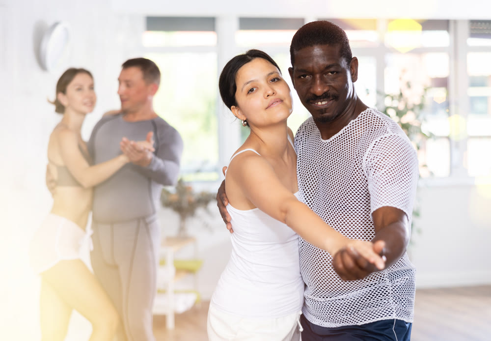 Asian woman and African American man practicing ballroom dances in pair