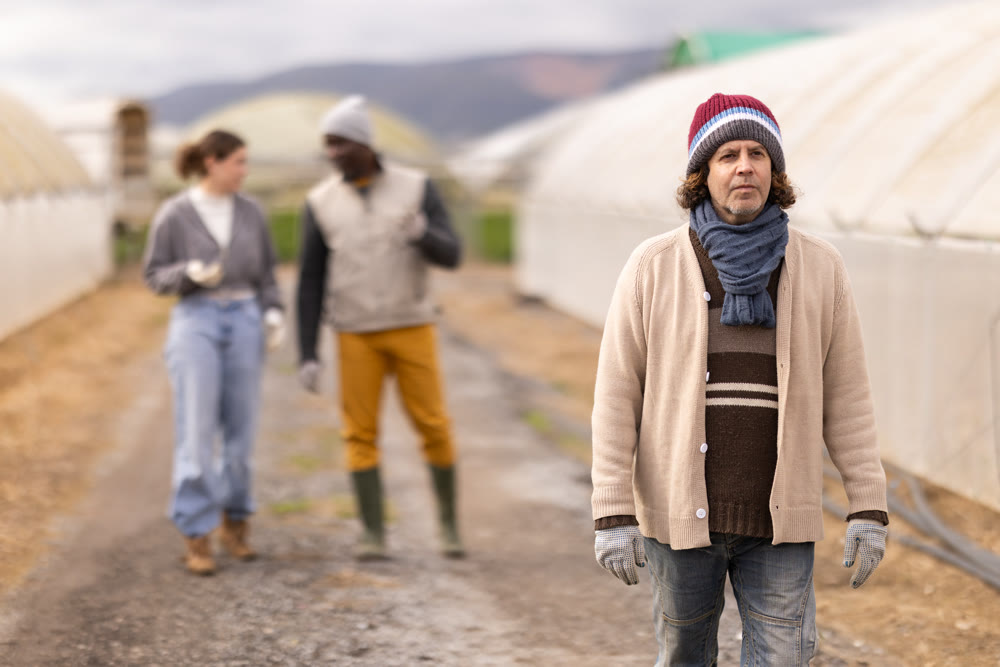 Adult male farmer with team at greenhouses