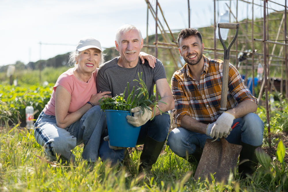 Portrait of happy family with an adult son and harvest of onions in their hands