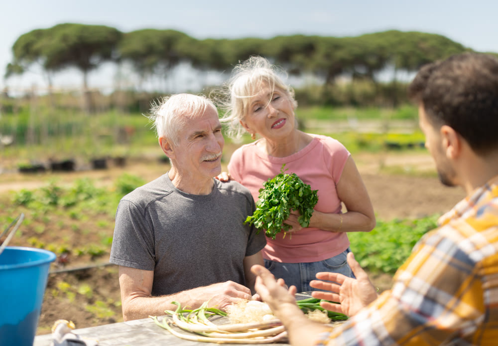 Happy family of farmers sits at table and discusses current affairs