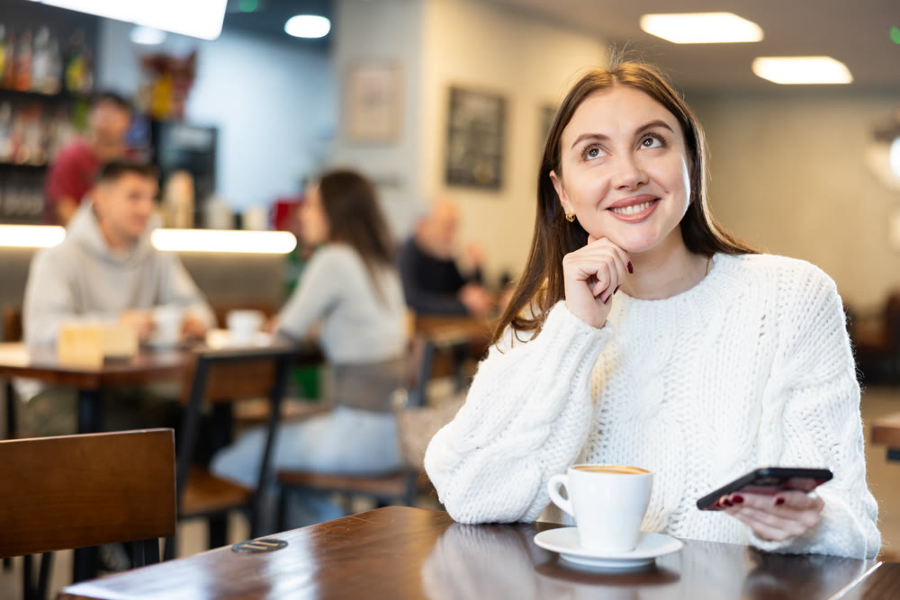 Young woman with phone in cafe