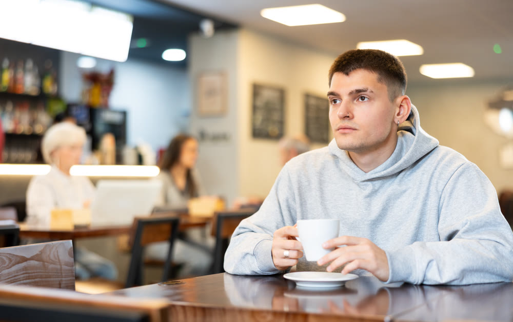 Guy drinking coffee in a cafe