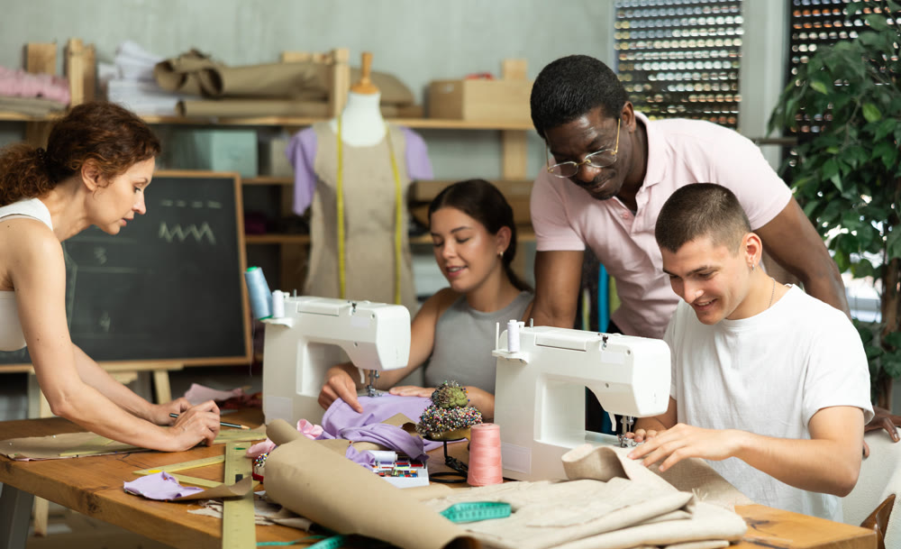 Experienced sewing instructor overseeing students in fashion course