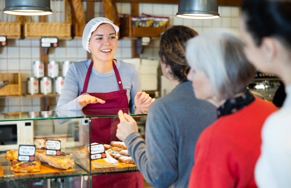 People place order at bakery, buy sweet pastries in cafeteria, girl worker serving people