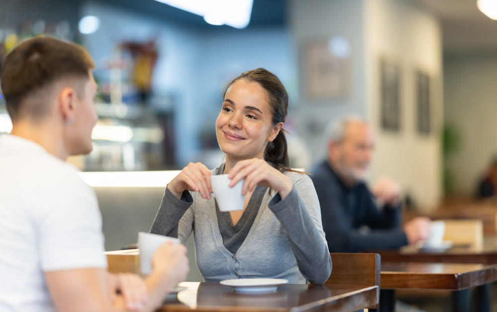 Girl in cafe sits near guy companion, has nice conversation