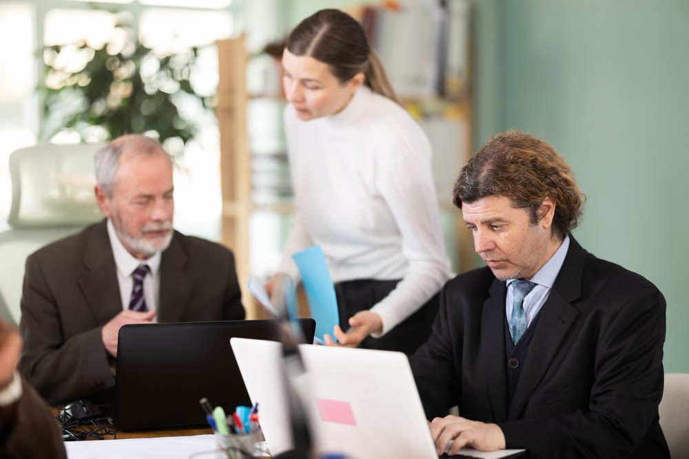 European man working on laptop with room in office