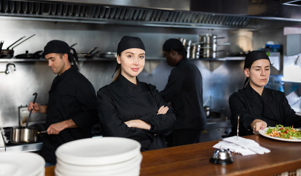 Woman executive chef posing in restaurant kitchen