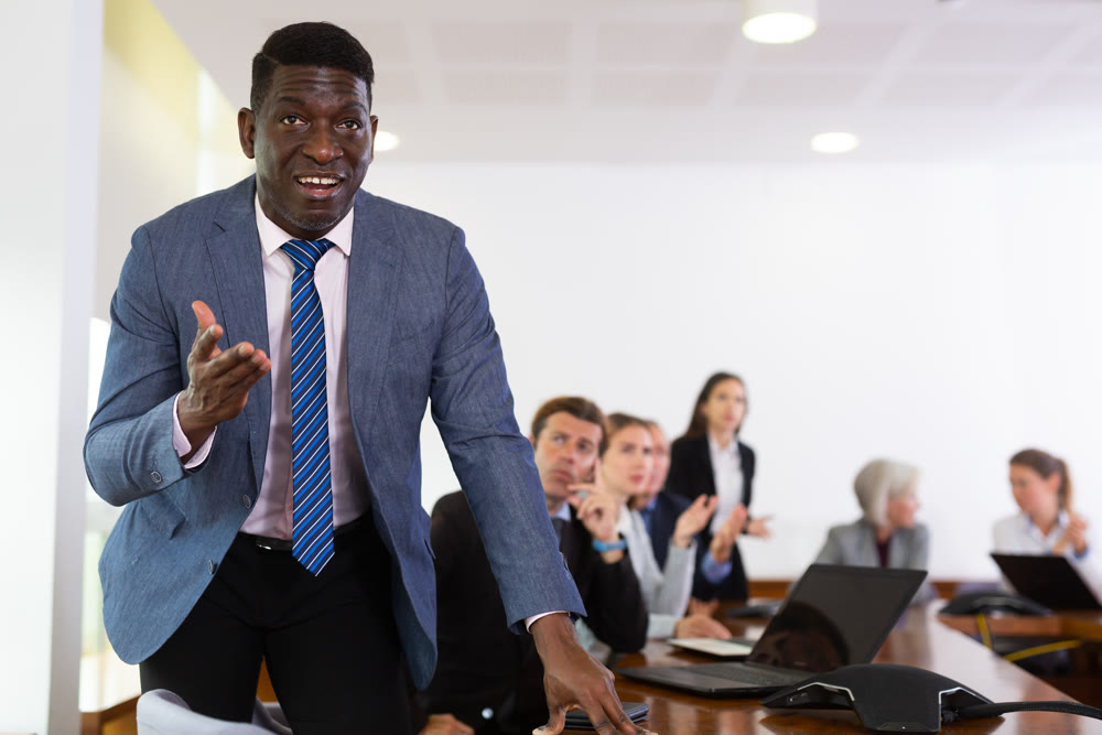 Managers expressing dissatisfaction with teamwork of colleagues at meeting