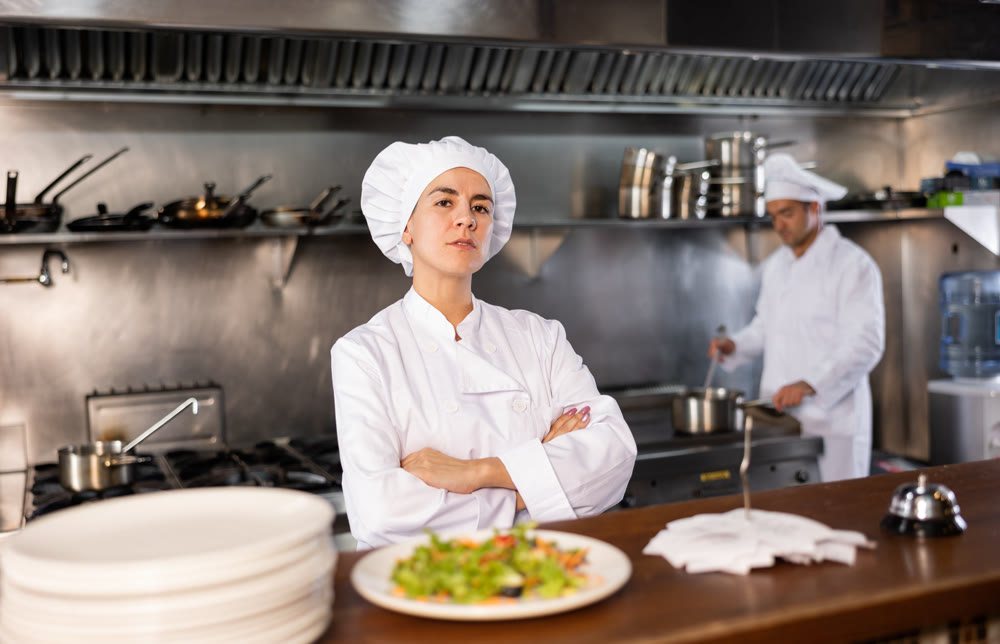 Woman head chef posing in restaurant kitchen