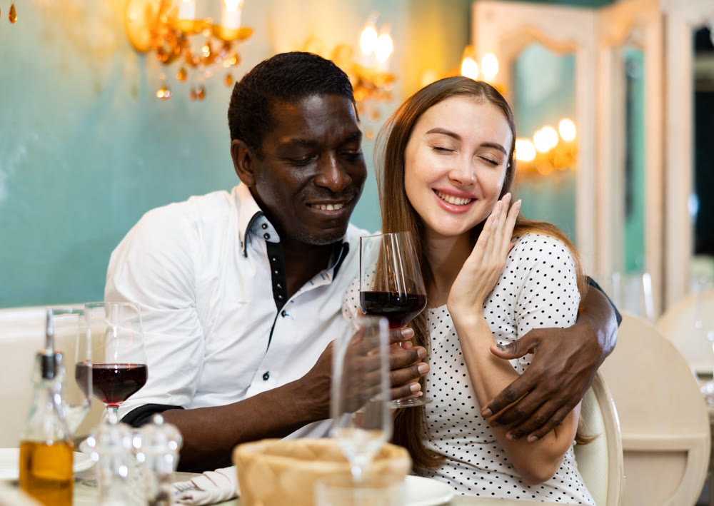 Adult couple on romantic date drinking red wine at restaurant