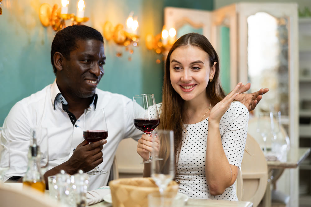 Adult couple on romantic date drinking red wine at restaurant