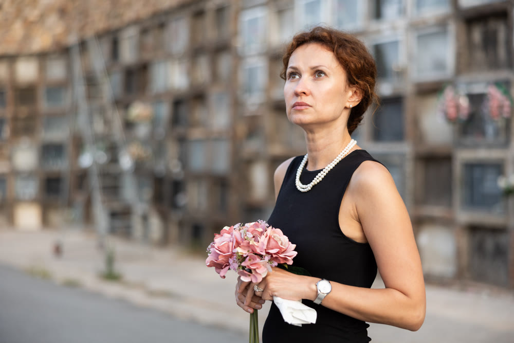 Woman brought flowers to the cemetery and cries over the death of beloved relative