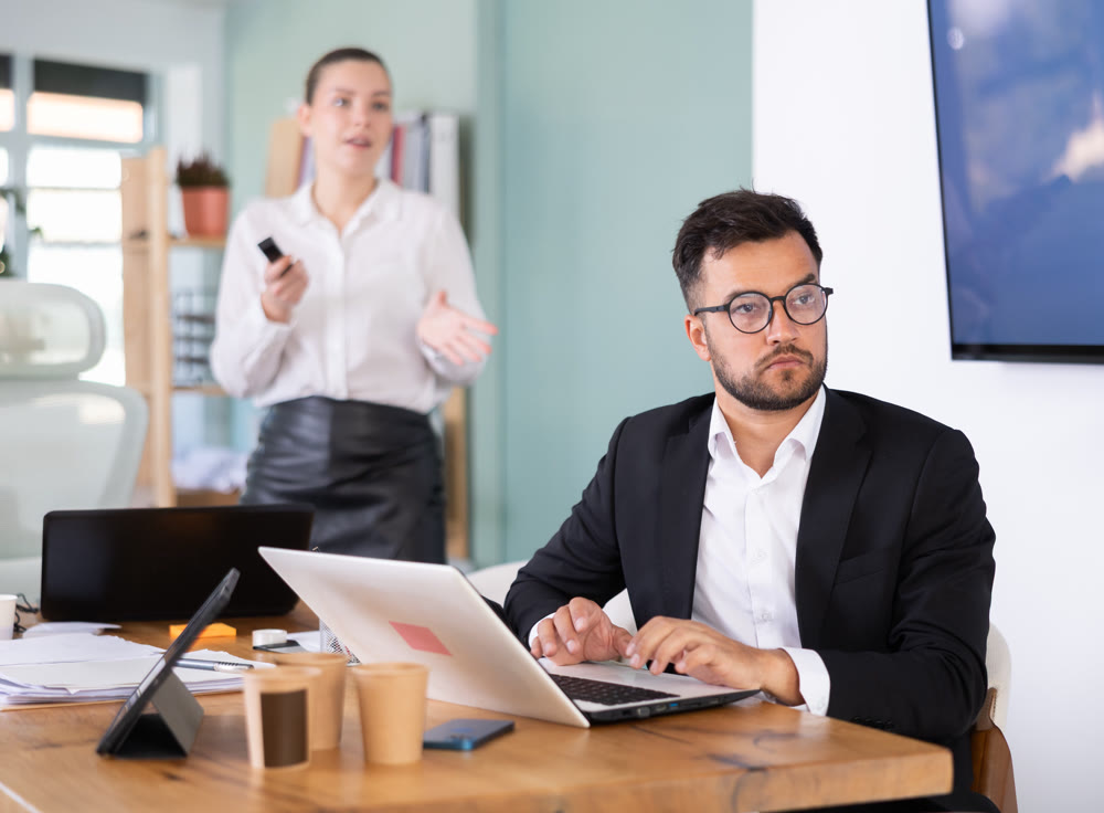 Male and female colleagues are watching presentation in office