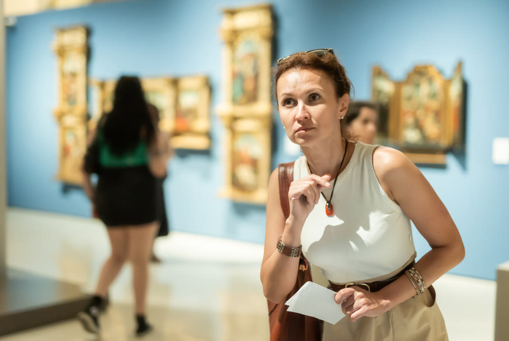 Woman looks at hall of paintings and sculptures
